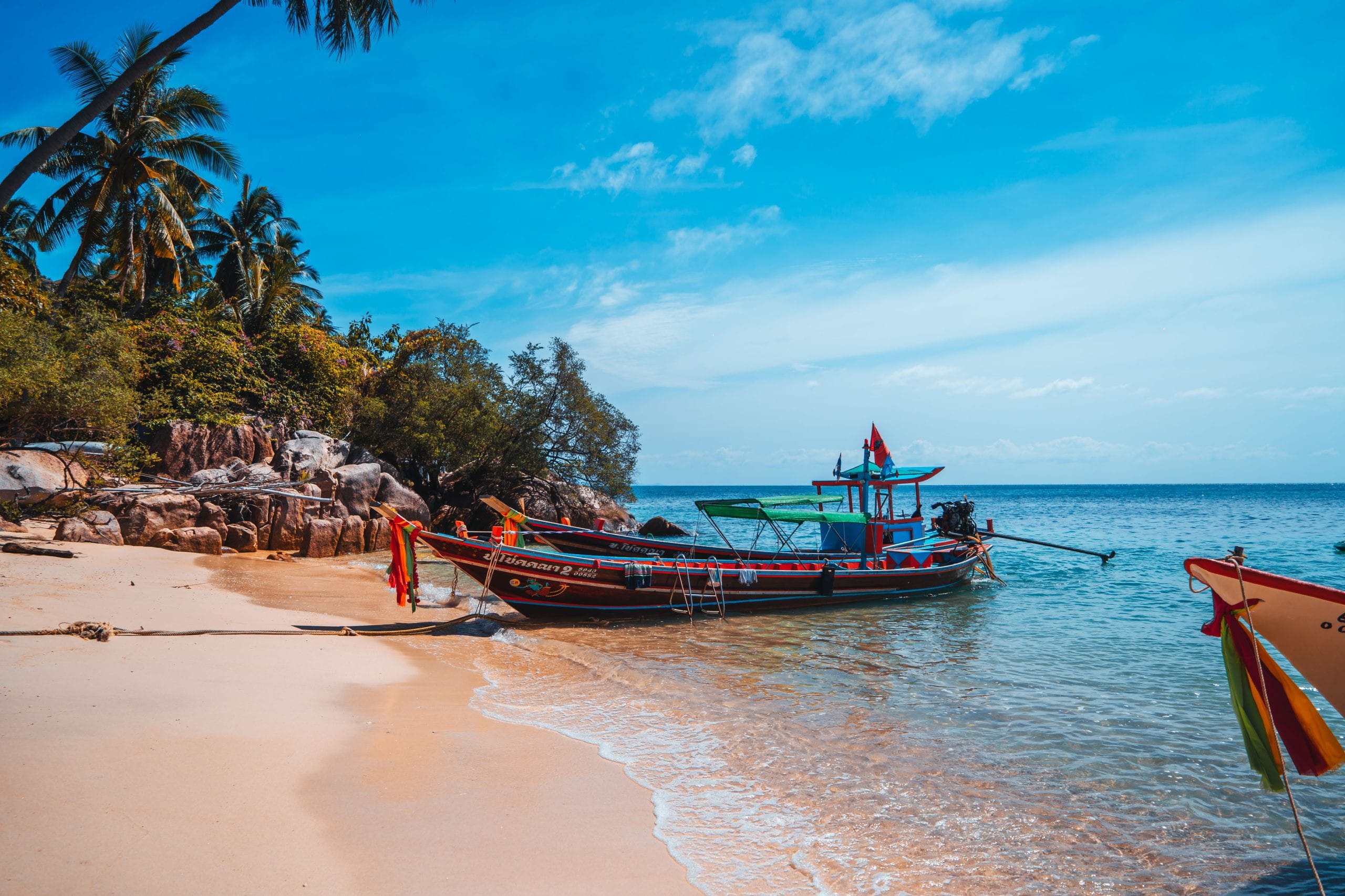 A longtail boat on the sand, the way to reach the bays with no road access