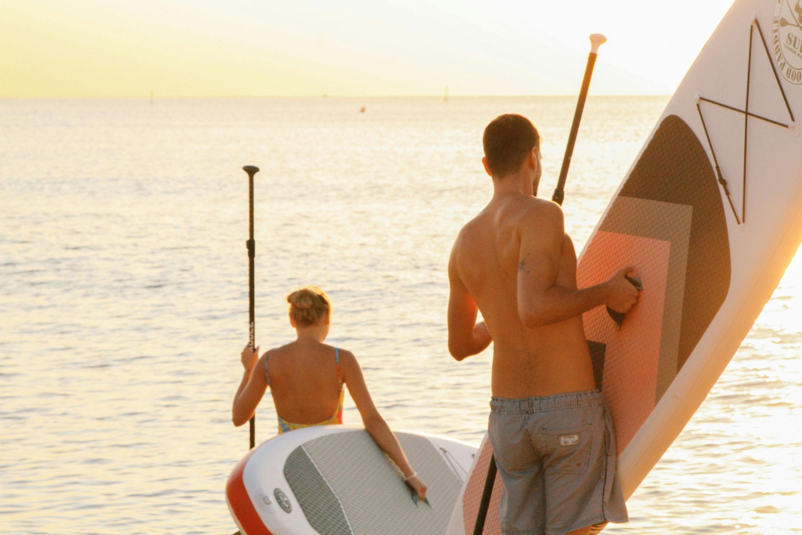 Two paddleboards being carried down to the water on Koh Tao